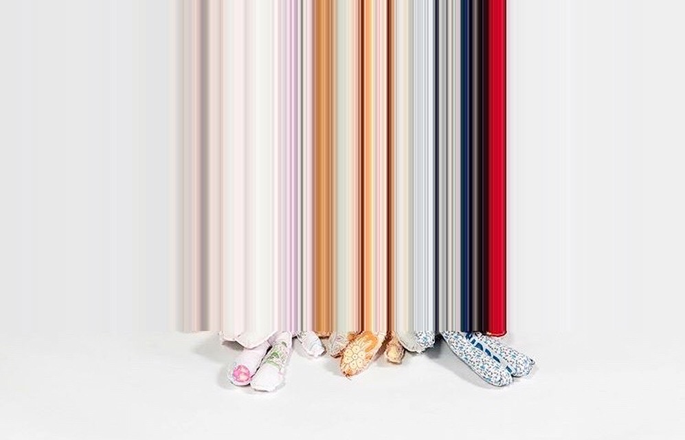 Fabric doll feet at the base of vertical streaks of colour