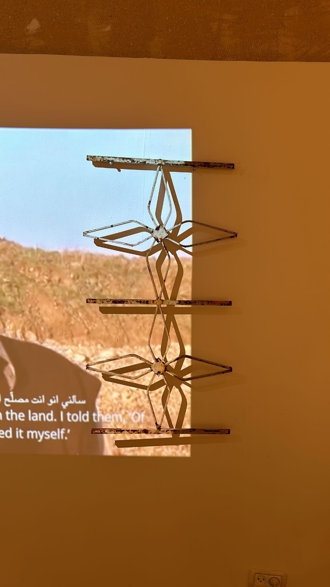 Iron window grille mounted over a projected video of a field